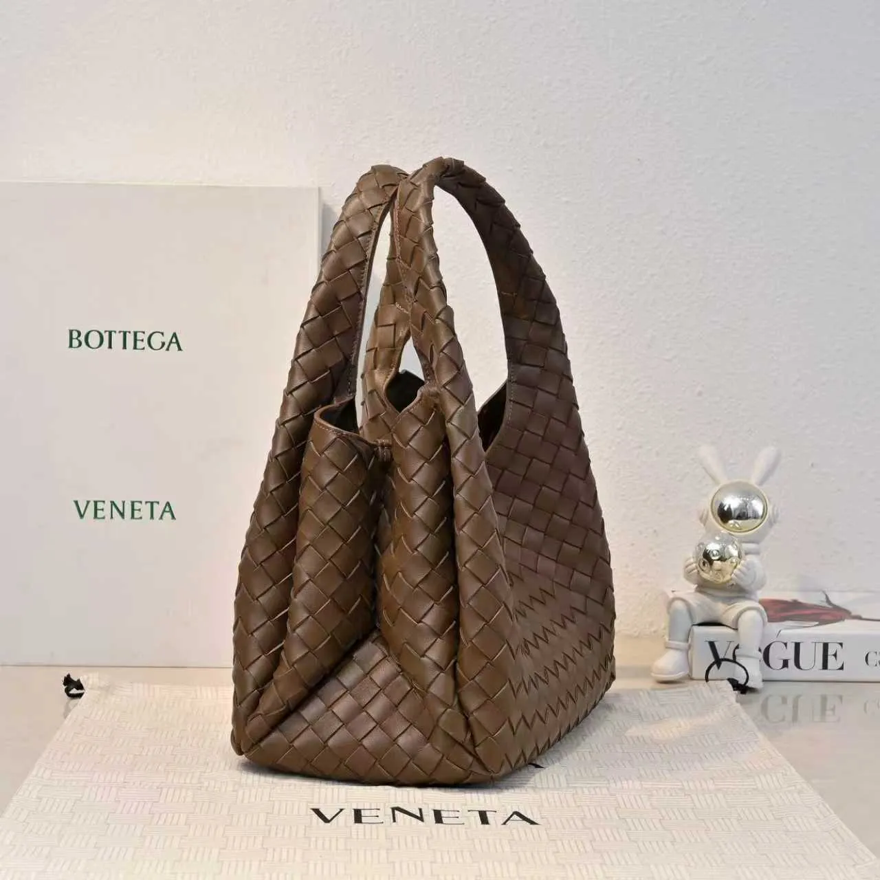 Batch 2160 new products are coming! BOTTEGA VENETA Bottega Veneta's 2025 new Campana shoulder bag is on the market~ First of all, I would like to praise the weight of this bag. As a not too small bag, it is very light for daily use. For people like me who need to carry a lot of belongings when going out, this advantage is great, and it greatly reduces the burden of traveling. 🛍️The shape is a bit like a combination of parachute and jodie. The blunt triangle shape is cute and honest. Carrying it on your back when going shopping is a good mood accelerator. The handles and body of the bag are both classic weaves. A tie is added to the original open design. If it is not tied up, the bag will look like a small vegetable basket when carried. Style number: 4249 Size: 33*20*16.5cm